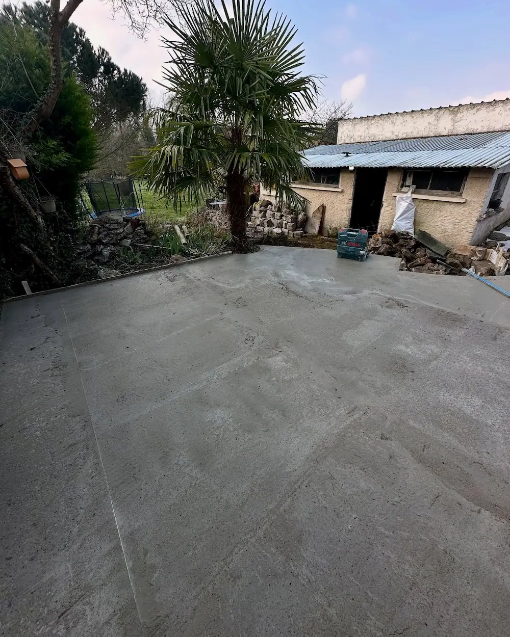 Coulage de la dalle béton servant de support avant la pose du revêtement en travertin.