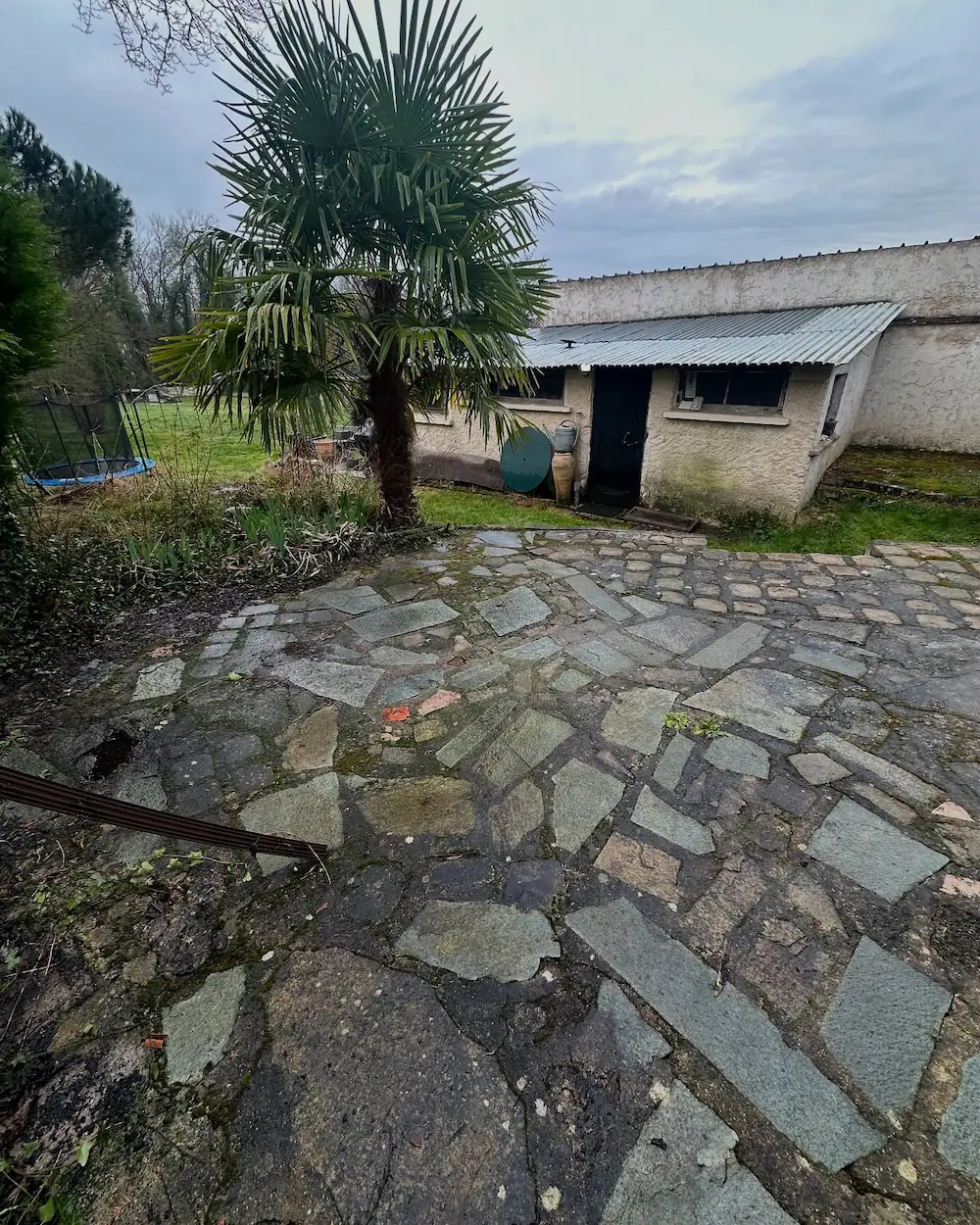 Terrasse vieillissante avant travaux, avec revêtement usé et surface irrégulière.